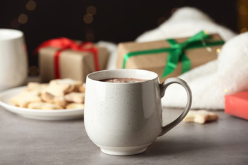 Delicious hot cocoa drink in white cup on grey table