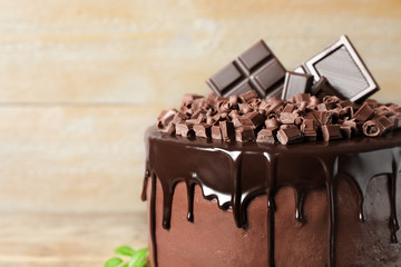 Freshly made delicious chocolate cake against wooden background, closeup. Space for text