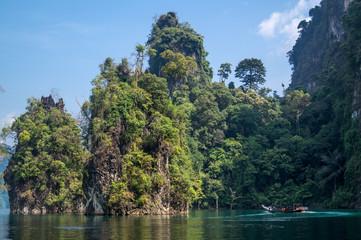 Fototapeta na wymiar boat driving through islands covered in jungle