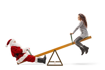 Santa Claus sitting on a seesaw with a young woman