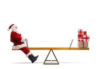Santa Claus on a seesaw with a pile of presents on the other side