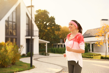 Beautiful sporty woman running on street. Healthy lifestyle