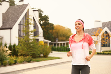 Beautiful sporty woman running on street. Healthy lifestyle