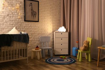 Modern baby room interior with white chest of drawers in evening