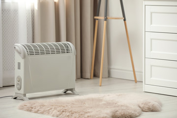 Modern electric heater on floor at home