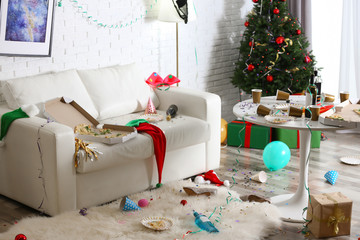 Messy living room interior with Christmas tree. Chaos after party