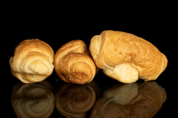 Group of three whole fresh baked mini croissant isolated on black glass