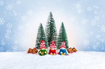 Knitted dolls with bells in colorful sweaters with fir trees and Christmas presents
