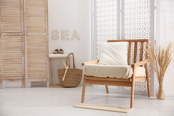 Stylish room interior with white folding screen and armchair