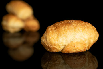 Group of four whole fresh baked mini croissant one in focus isolated on black glass