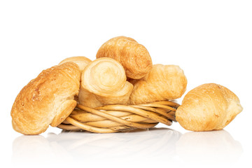 Lot of whole fresh baked mini croissant in wicker vine circle isolated on white background