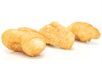 Group of three whole fresh baked mini croissant in row isolated on white background