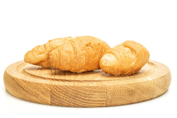 Group of three whole fresh baked mini croissant on bamboo plate isolated on white background