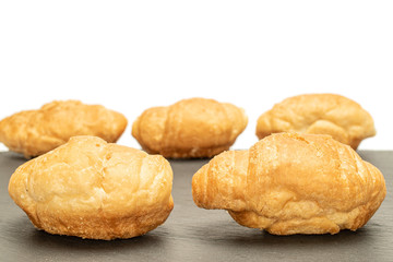 Group of five whole fresh baked mini croissant on grey stone isolated on white background