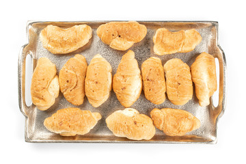 Lot of whole fresh baked mini croissant on tray flatlay isolated on white background