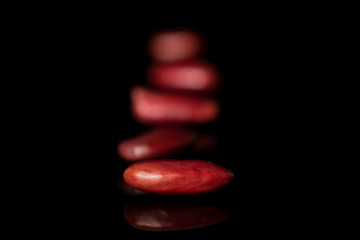 Fototapeta na wymiar Group of five whole fresh red kidney beans isolated on black glass