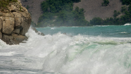 sea shore big rocks waves spray and foam