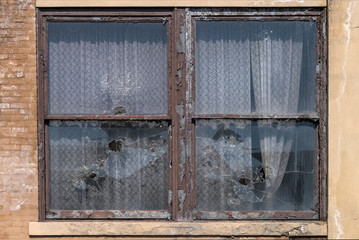 Broken windows with lace curtains.  Image taken at the old Scranton Lace Factory, built in 1890, closed in 2002, demolished in 2019.