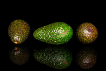 Group of three whole fresh green avocado isolated on black glass