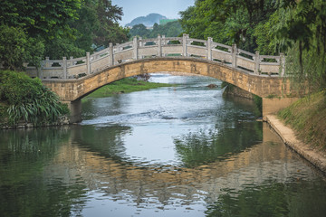 Fototapeta na wymiar Arched old bridge on Li River in Elephant Trunk Hill Park