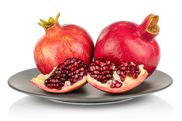 Group of two whole two quarters of fresh red pomegranate on gray ceramic plate isolated on white background