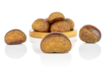 Fototapeta na wymiar Group of eight whole sweet brown chestnut on bamboo coaster isolated on white background