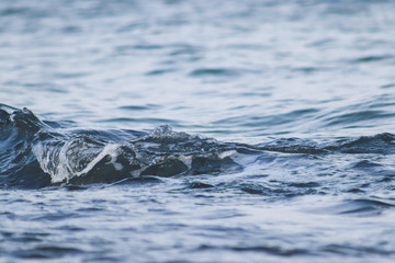 Fototapeta premium Beautiful blue sea water surface with low waves. Seascape background. Calm Dark Sea Waves. Close-up, shallow focus.