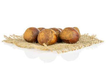 Lot of whole sweet brown chestnut on natural sackcloth isolated on white background