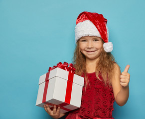  Girl in Santa red hat holding Christmas gift