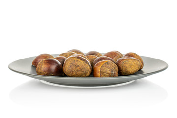 Lot of whole sweet brown chestnut on gray ceramic plate isolated on white background