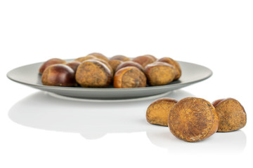 Lot of whole sweet brown chestnut on gray ceramic plate isolated on white background