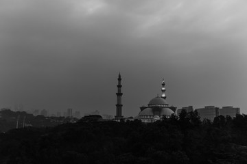 Sunrise over silhouette mosque and hazy