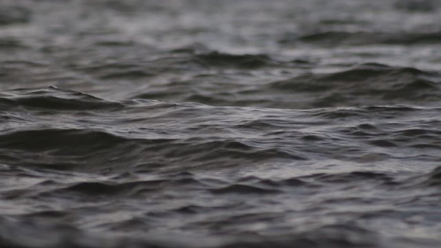 Beautiful   blue sea water surface with low waves. Seascape background. Calm Dark Sea Waves. Close-up, shallow focus. Low light