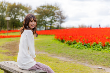 女性　花畑　赤　横正面　コピースペース 
