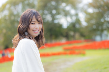女性　横顔　笑顔　背景花畑　秋　コピースペース 
