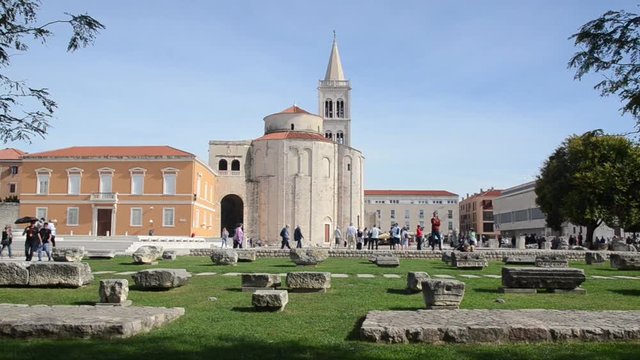Tourists in front of  Cathedral of St. Anastasia and Roman forum with Corinthian column in center of Zadar, Dalmatia, Croatia. Sveti Donat and Zeleni Trg city square. 