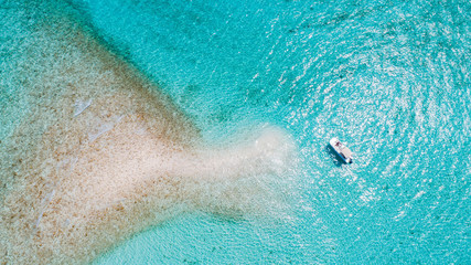 Aerial of boat parked at private island by tropical reef