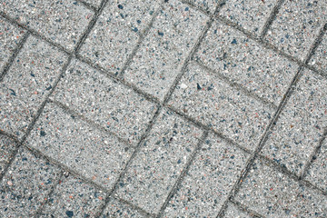 Pavement gray mosaic brick blocks background. Grunge dirty road texture.
