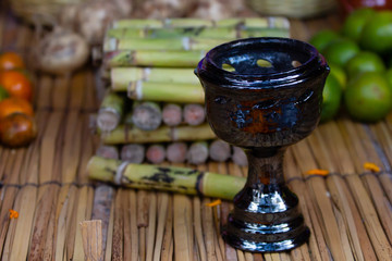 a handmade mexican clay pot for burning incense for day of the dead, on a traditional handmade petate