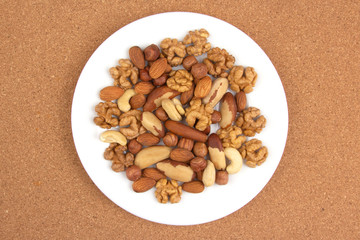 Different kinds of nuts on a white plate. Healthy and protein food.