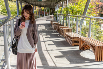 女性　スマートフォン　いじる　操作