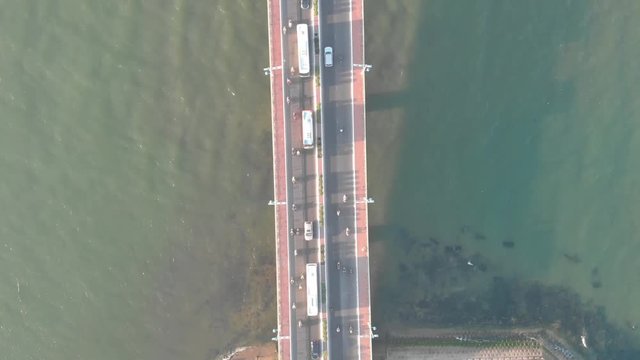 a flying camera flies over a bridge in Vietnam in the city of Nha Trang, overlooking the river, boats, road traffic, various views, top to bottom