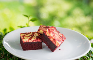Red velvet cream cheese brownies on white dish