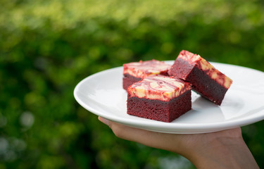 Red velvet cream cheese brownies on white dish