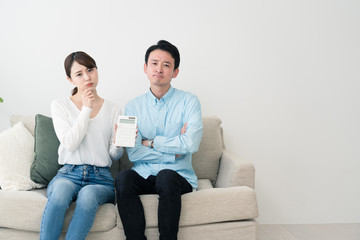 電卓を持って考える若い男女