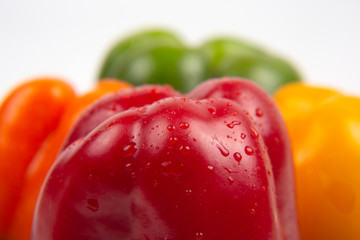 Fresh colored bell peppers on a white background. Vitamin wholesome food.