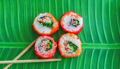 Sushi on a tray of green food