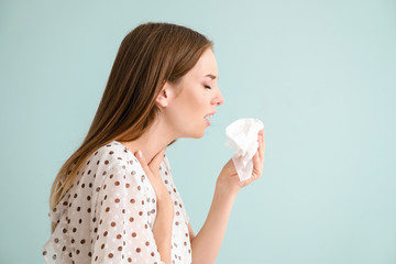 Young woman suffering from allergy on light background - obrazy, fototapety, plakaty