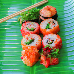 Sushi on a tray of green food