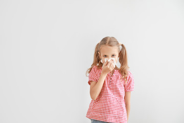 Little girl suffering from allergy on light background